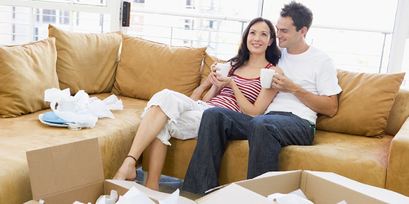 An Image Showing Couple Sitting In A Couch Afetr Relocating Process.