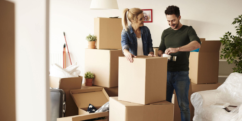 A Young Couple Packing Their Home Goods For Relocation Purpose.