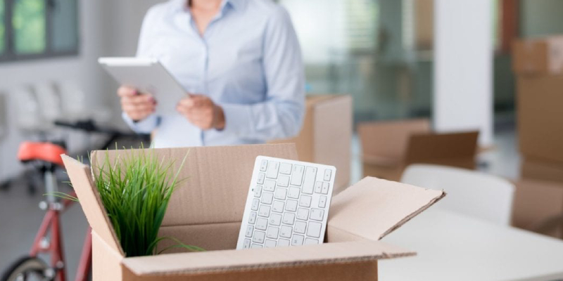 A Box Containing Keyboard Infront Of A Woman With Tablet In Her Hand.