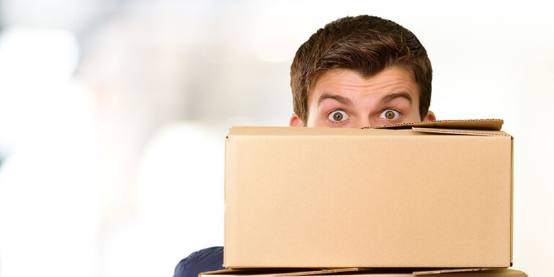 A Man Stare From The Cardboard Box Behind During Relocation.