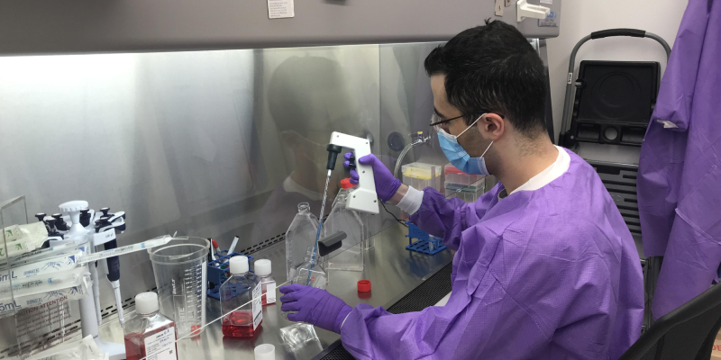 A scientist is working with lab equipment at the lab center, some chemical solutions can be seen there.